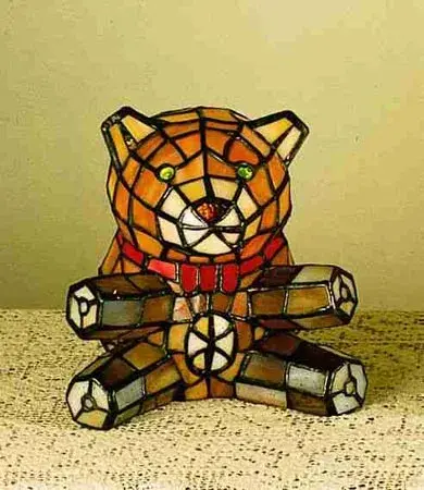 Shower your baby with beautiful ambient light with this authentic stained glass Teddy Bear. A charming lighted Tiffany styled sculpture, this design features the lovable character in Amber art glass. He is wearing an adorable Red bow tie and has stunning Red jeweled eyes. Handcrafted of individual pieces of stained glass using the famous Meyda Tiffany copperfoil construction process. Ideal as a fine gift to adorn a children's room or tabletop. UL and cUL listed for dry locations. Collection: Teddy Bear Finish: Multi Glass: Ha Ba Xa Width: 6.00" Height: 7.00" Length: 6.00" Weight: 2.00 lb Number of Bulbs: 1 Maximum Wattage: 25.00 W Bulb Type: B10 Bulb Base: E12 Material: Steel Country of Origin: CHINA Safety Listing: Dry Safety Rating: Dry