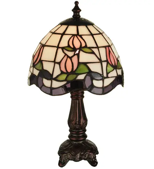 Grace your home with the elegant Roseborder Mini Lamp. This lamp features an exquisitely crowned shade revealing a gridwork of Beige art glass adorned with a Plum Waterglass border of swirling ribbons and perfect Pink Rosebuds with Green Leaf accents. The art glass shade is created using the famous Meyda Tiffany copper foil construction and embraced by an elegant cast metal base finished in Mahogany Bronze. The Roseborder Table Lamp is included in our American designed, handcrafted Stained Glass Lighting Collection. UL and cUL listed for dry locations.? Each shade is a unique work of art with color variations based on natural ingredients inherent in the glass. Contact us if color matching is critical when ordering multiple items. Collection: Roseborder Finish: Mahogany Bronze Glass: Ca Ja Pac (Purple Waterglass) Width: 7.00" Height: 12.00" Length: 7.00" Weight: 2.00 lb Number of Bulbs: 1 Maximum Wattage: 25.00 W Bulb Type: B10 Bulb Base: E12 Material: Zinc Country of Origin: CHINA Safety Listing: Dry Safety Rating: Dry - alternate view