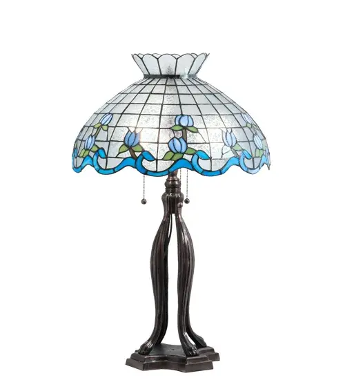 Grace your home with this elegant crowned shade. It features a gridwork of Winter-kissed Icy Clear Fern Glass adorned with a Wedgewood Blue border of swirling ribbons and Blue Waterglass rosebuds accented with Green Leaf accents. The Tiffany style stained glass shade is made of hand cut and copperfoiled glass. The shade is embraced by a table base finished in Mahogany Bronze. The shade is created using the famous Meyda Tiffany copperfoil construction. UL and cUL listed for dry locations. - alternate view