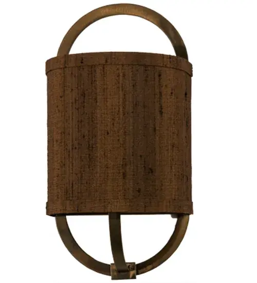 This elegant fabric wall luminaire blends fine American craftsmanship with quality materials. The Cocoa-colored fabric is set against a steel oval frame with a backplate featured in an Antique Copper finish. The sconce was custom built with the customer's own materials; as a feature of our custom lighting program. Other customers are welcome to send us their own hard backed materials to have this sconce custom furnished. The custom lighting design and production occurs at our manufacturing facility in Yorkville; New York. Contact factory for details. - alternate view