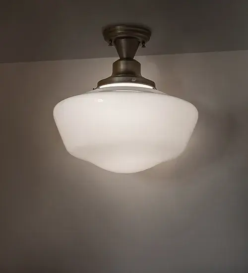 Restore the past with this appealing ceiling fixture featuring a beautifully formed White Opal Schoolhouse Glass shade. The fixture is enhanced with Solid Antique Brass hardware featuring a Hand-Polished Premium Finish. This vintage-style lighting fixture offers a refined yet consistent; distinctive design that originated in traditional schoolhouses and public buildings in the early 1920s. The ceiling fixture is perfect for dining spaces and corridors in structures from Wells; Maine; to Columbia County; New York; to Canaan; Pennsylvania. The Revival Schoolhouse Traditional Globe Flushmount is included in our American-designed; handcrafted Schoolhouse Lighting Collection. The fixture is UL & cUL listed for dry and damp locations.