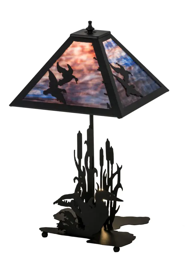 Ducks are soaring into the sky in this wildlife inspired original table lamp. Beautiful ambient lighting is projected through an Purple Blue art glass shade. The shade is enhanced with a Textured Black finished table base featuring a Duck swimming among the marsh and Cattails. This lamp is offered with a 3-section switch so the shade can be illuminated; the base can be lit as a night light; or both can be illuminated together. Handcrafted by highly skilled artisans in our 180;000 square foot manufacturing facility in Yorkville; New York; located at the foothills of the Adirondack Mountains. Wildlife and other custom designs are available. UL and cUL listed for dry locations.