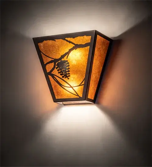 Listen closely. You can almost hear the soft whisper of the Pine branches as they dance in the wind. Enjoy the ambiance of soft beautiful light diffused through Amber Mica, which features stunning Pinecone and tree branch designs in a warm Mahogany Bronze finish. This sconce is handcrafted by highly skilled artisans in Yorkville, New York at the foothills of the breathtaking Adirondack Mountains. Custom sizes, styles and finishes are available, as well as dimmable energy efficient lamping options such as LED. The fixture is UL and cUL listed for damp and dry locations. Collection: Whispering Pines Finish: Mahogany Bronze Glass: Amber Mica Width: 13.00" Height: 11.50" Length: 6.50" Weight: 4.50 lb Extension from Wall: 6.50" Number of Bulbs: 2 Maximum Wattage: 60.00 W Bulb Type: A19 Bulb Base: E26 Light Source: LED Material: Steel Country of Origin: USA Safety Listing: Damp Safety Rating: Damp LED