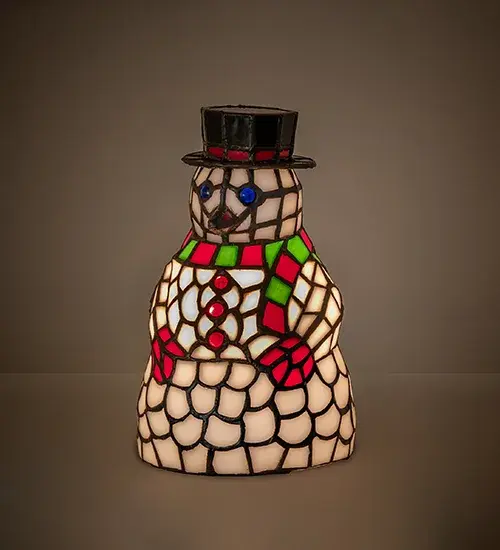 Meyda Tiffany presents the Snowman Accent Lamp. Tis the season to display a wonderful decorative accent lamp designed as the iconic figure of the winter wonderland. The always warm and charming holiday sculpture is created in Winter White with Berry Red and Pine Green accents and Blue eyes that will take the chill out of the coldest days. The lighted sculpture is handcrafted of individual pieces of stained glass using the famous Meyda Tiffany copperfoil construction process. Warm your heart and holiday spirit with this Snowman displayed on tabletops; countertops; mantels; and picture windows in fine homes nationwide. The Snowman Accent Lamp is included in our American-designed; handcrafted Holiday Collection. UL and cUL listed for dry locations.