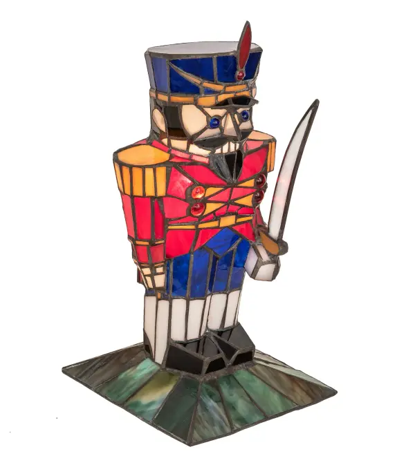 Warm your heart and imagine this colorful Toy Soldier on your shelf or over the mantle. A charming lighted Tiffany styled sculpture, the Nutcracker lighted sculpture is adorned in a handsome uniform featured in Red, Blue and White art glass with Amber glass trim. Handcrafted of individual pieces of stained glass using the famous Meyda Tiffany copperfoil construction process. UL and cUL listed for dry locations. The Nutcracker Mini Lamp is included in our American designed, handcrafted Holiday Stained Glass Lighting Collection. UL and cUL listed for dry locations. Each lighted sculpture is a unique work of art with color variations based on natural ingredients inherent in the glass. Collection: Nutcracker Finish: Craftsman Brown Glass: Red Opal/Blue Water/Root Beer/Honey Amber Width: 7.00" Height: 15.00" Length: 8.00" Weight: 3.00 lb Extension from Wall: 7.00" Number of Bulbs: 1 Maximum Wattage: 25.00 W Bulb Type: B10 Bulb Base: E12 Material: Metal Country of Origin: CHINA Safety Listing: Dry Safety Rating: Dry