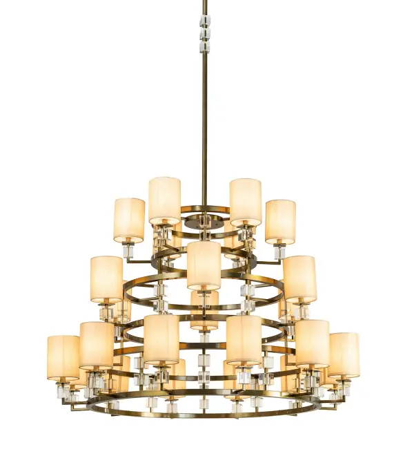 Transform a fine room into your stately domain with Montecito Ritz. This lustrous gem of illumination emits radiance for a special decor. The luxurious chandelier shimmers with elegant rings and a seductive glow. 24 Natural Silk shades feature Contrail Mist Idalight diffusers with Clear Crystal Glass Cube accents. The shades are complemented with Brass powder coated accents and hardware. Handmade in our 180,000 square foot manufacturing facility in Yorkville, NY. UL and cUL listed for dry and damp locations, however, we do not recommend installing it in spaces that experience a large amount of moisture due to the fabric shades. Collection: Montecito Finish: Brass Powder Coat Glass: Natural Wafer Silk/Statuario Idalight/Clear Glass Width: 60.00" Height: 118.00" Length: 60.00" Weight: 165.00 lb Extension from Wall: 11.00" Number of Bulbs: 24 Maximum Wattage: 6.00 W Bulb Type: B11 Bulb Base: E12 Light Source: LED Material: Steel Country of Origin: USA Safety Listing: Dry Safety Rating: Damp LED