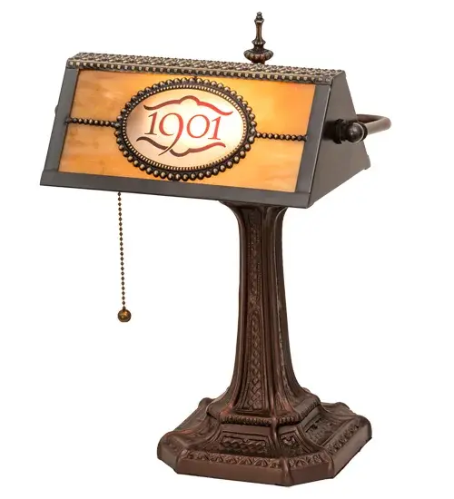This attractive banker's lamp is personalized with the 1901 graphics sand-carved in Red on Clear glass and complemented with Beige art glass. The shade is enhanced with a table base offered in a Mahogany Bronze finish. The Personalized 1901 Banker's Lamp is included in our American-made; American-designed; handcrafted Personalized Collection and manufactured in Yorkville; New York. The fixture is UL and cUL listed for dry locations. This personalized lamp can be ordered by calling us and adding your business logo or family name for your next project. Please call for pricing and lead time. - alternate view