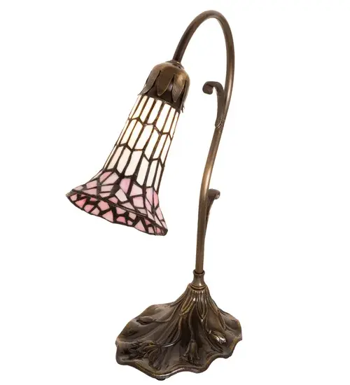 Inspired by the popular Tiffany design from the early 1900s... This mini lamp offers an attractive, delicate design featuring a stunning shade in Pink and White created with the famous Meyda Tiffany copperfoil construction. The Pond Lily shade is embraced by an elegant cast base that is finished by hand in Antique Brass. The Pond Lily Mini Lamp is featured in our American designed, handcrafted Stained Glass Lighting Collection. Each shade is a unique work of art with color variations based on natural ingredients inherent in the glass. Contact us if color matching is critical when ordering multiple items. Collection: Stained Glass Pond Lily Finish: Antique Brass Glass: Pink/White Width: 7.00" Height: 15.00" Length: 7.00" Weight: 3.50 lb Number of Bulbs: 1 Maximum Wattage: 40.00 W Bulb Type: B10 Bulb Base: E12 Material: Zinc Country of Origin: CHINA Safety Rating: Dry - alternate view