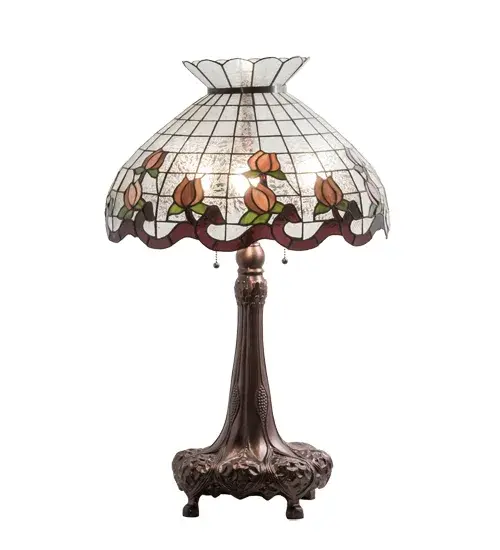 Grace your home with the elegant Roseborder table lamp. An exquisitely crowned shade features a gridwork of Fern art glass adorned with a Plum Waterglass border of swirling ribbons and perfect Pink Rosebuds with Green Leaf accents. The art glass shade is made of hand cut glass using the famous Meyda Tiffany copperfoil construction process. The lovely shade embraces a table base finished in Mahogany Bronze. UL and cUL listed for dry locations. Each shade is a unique work of art with color variations based on natural ingredients inherent in the glass. Contact us if color matching is critical when ordering multiple items. Collection: Roseborder Finish: Mahogany Bronze Glass: Zaz Pa Tac Width: 20.00" Height: 33.00" Length: 20.00" Weight: 16.50 lb Number of Bulbs: 3 Maximum Wattage: 60.00 W Bulb Type: A19 Bulb Base: E26 Material: Steel/Zinc Country of Origin: CHINA Safety Rating: Dry - alternate view