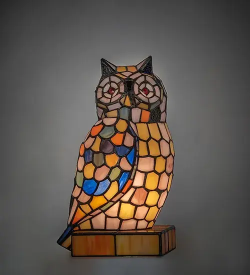 A beautiful representation of the Wise Majestic Owl; this charming accent lamp symbolizes transformation; intuitive development; good luck; and self-actualization. This lighted art glass sculpture is created using the famous Meyda Tiffany copperfoil construction technique in Blue; Green; Orange; Amber; and Pink art glass; accented with Red Jewel eyes. The figure sits on an integral matching stained glass base. The lamp is ideal as an illuminating accent piece on mantels; credenzas; occasional tables; and other spaces in residential and hospitality settings. Inspired by iconic Owls throughout the US; from Santee and Hardeeville; South Carolina; to Cook County; Illinois; to Portland; Oregon; to Redwood National and State Parks throughout California. The Owl Accent Lamp is included in our American-designed Stained Glass Collection. UL and cUL listed for dry locations. Each lamp is a unique work of art with color variations based on natural ingredients inherent in the glass. Please contact us if color matching is critical when ordering multiple items.