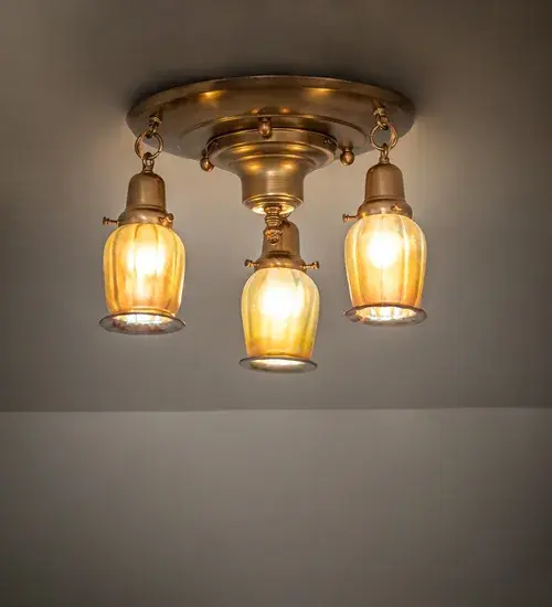 Recreating Tiffany's famous Favrile Lily design from the early 1900s... This Brass ceiling fixture is created with three mouth blown shades featuring Gold Iridescent Glass. The Squash Blossom styled shades are embraced by elegant cast hardware featuring a Brushed Brass finish. The Revival Favrile 3 Light Flushmount is featured in our American made; American designed; handcrafted Favrile Lighting Collection. Manufactured in Yorkville; NY. UL and cUL listed for dry and damp locations. Each shade is a unique work of art with color variations based on natural ingredients inherent in the glass. Contact us if color matching is critical when ordering multiple items.