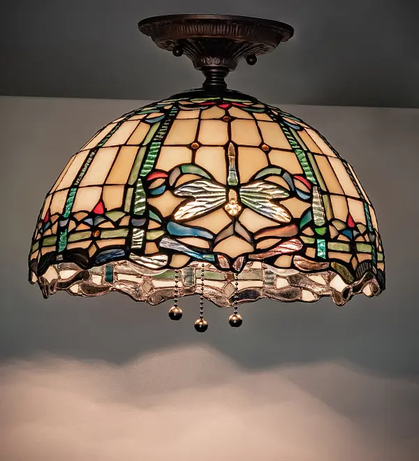 Inspired by Tiffany Studio's beloved stained glass Dragonfly design; this ceiling fixture is modeled after the original design. Dragonflies; designed with glowing jeweled eyes and delicate multicolored wings; circle over Beige Art Glass with Ruby; Green; and Blue accents. The shade is created using the famous Meyda Tiffany copperfoil construction and complemented with hardware finished in a warm hand-applied Mahogany Bronze finish. The Tiffany Dragonfly Flushmount is included in our American-designed; handcrafted Tiffany Reproduction Lighting Collection. UL and cUL listed for dry and damp locations. Each shade is a unique work of art with color variations based on natural ingredients inherent in the glass. Please contact us if color matching is critical when ordering multiple items.