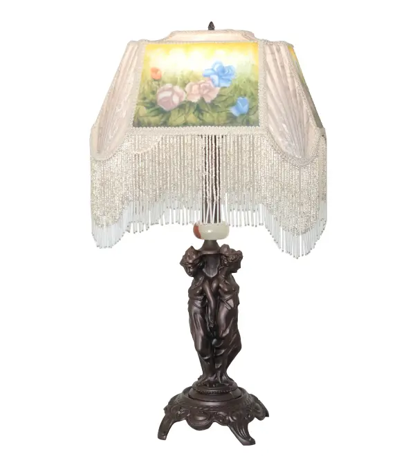 This exquisite table lamp will add elegance and romance to any room in a residence or business. A beautiful; uniquely shaped Ivory Textrene shade is highlighted with a Reverse Handpainted Medallion featuring a stunning spray of Colorful Roses. This elegant; oblong-shaped shade is accented with Color-Coordinated Ivory and Clear Glass Beaded Fringe and paired with a sculpted statuesque Three Graces metal base featured in a Mahogany Bronze finish. Create a dramatic design statement in homes; hotels; and other spaces nationwide; from Williamsburg; Virginia; to Frankenmuth; Michigan; to Luckenbach; Texas. The Reverse Painted Roses Table Lamp is included in our American-designed; handcrafted Fabric & Fringe Collection. UL & cUL listed for dry locations.