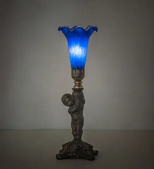 Inspired by the famous Tiffany design from the early 1900s. This mini lamp features a stunning shade mouth blown of Blue Favrile-style art glass. The Pond Lily shade is embraced by an elegant cast base featuring a charming cherub finished by hand in Antique Brass. The lamp is perfect for placement in a picture window; desk; or credenza in homes from High Point; North Carolina; to El Paso; Texas. The Pond Lily Mini Lamp is featured in our American-designed; handcrafted Favrile Glass Collection. UL and cUL listed for dry locations. Each shade is a unique work of art with color variations based on natural ingredients inherent in the glass.