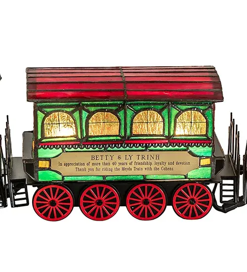 A charming Art Glass Train Carriage features the Utica Club name in Red on one side and the Saranac brand in Red on the other; with matching wheels and roof. The train also displays Green and Amber glass. This charming figure is created using the famous Meyda Tiffany construction process. Sold individually or as a 3-piece set. A lighted Tiffany-styled sculpture that serves as the perfect gift. Inspired by homes throughout the US; from Bethlehem; Pennsylvania; to Williamsburg; Virginia; to Leavenworth; Washington. The Train Carriage Lighted Sculpture is included in our American-designed; handcrafted Holiday Collection. UL and cUL listed for dry locations. Each lamp is a unique work of art with color variations based on natural ingredients inherent in the glass. - alternate view