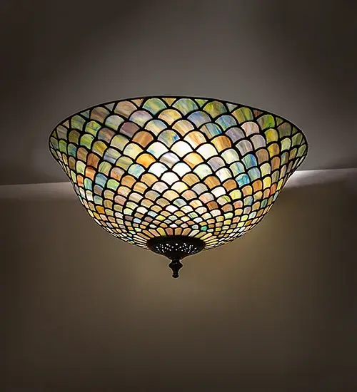 A Louis Comfort Tiffany studio classic... The renowned Fishscale design features a variegated Tortoiseshell of Emerald; Sapphire; Mauve; and Beige colored art glass; evoking a unique dimensional and textured look in a rainbow of brilliant hues. This exquisite art glass shade is created using the famous Meyda Tiffany copper foil construction process and enhanced with a Mahogany Bronze finish.?The hardware comes with three different sizes of rods: 3; 4.5" & 6" for various ceiling heights and applications. The Tiffany Fishscale Flush Mount is included in our American-designed; handcrafted Tiffany Reproduction Lighting Collection. It is UL and cUL listed for dry and damp locations. Each shade is a unique work of art with color variations based on natural ingredients inherent in the glass."