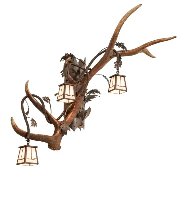 Capture the rustic charm of Naturally shed; hand-selected Antlers from Elk and Mule Deer in the northern Rocky Mountains. No animals are harmed; and all antlers are 100 percent authentic. This stunning wall sconce is adorned with three Whitestone Idalight lanterns and complemented with a Tyler Bronze finish. Please see the complementary fixture; the Antlers Elk 3 Light Right Wall Sconce; model 269303. The Antlers Elk 3 Light Wall Sconce is featured in our American-made; American-designed; handmade Antlers Lighting Collection and is manufactured in the USA. UL & cUL listed for dry locations. Our unique Antler fixtures are handcrafted using sustainably harvested; naturally shed Antlers. Each antler is unique; and natural variations may be expected from each one-of-a-kind piece.