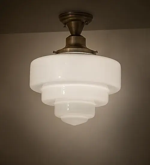 Restore the past with this appealing ceiling fixture featuring a beautifully formed White Opal Schoolhouse Glass shade with a tiered globe profile. The ceiling fixture is enhanced with Solid Antique Brass hardware. This vintage-style lighting fixture offers a refined yet consistent; distinctive design that originated in traditional schoolhouses and public buildings in the early 1920s. The fixture is perfect for dining spaces and corridors in homes; restaurants; and other public spaces. The Revival Schoolhouse Tiered Globe Flushmount is included in our American-designed; handcrafted Schoolhouse Lighting Collection. It is UL and cUL listed for use in dry and damp locations.
