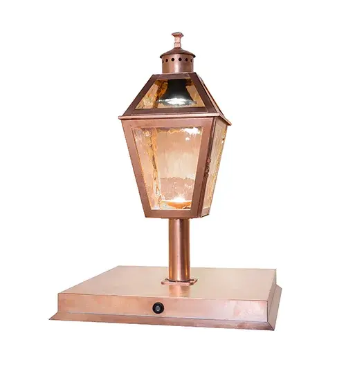 A timeless design combines classic styling and hand-craftsmanship to create the regal Corrina Lantern Post Mount for fine interiors and exteriors. The Rose Gold Art Glass Lens reveals a lamp that provides beautiful ambient lighting from within the lantern. The frame; decorative accents; and hardware are featured in Raw Copper and Clear Gloss finishes. The fixture is ideal for placement on posts and columns on decks and patios in timber homes; modern farmhouses; and other spaces. The fixture is designed with a door that opens for cleaning and maintenance; as well as a photocell sensor that turns on the outdoor light at Dusk and off at Dawn. The Corrina Post Mount is included in our American-made; American-designed; handcrafted Traditional Lighting Collection. The fixture is manufactured in Yorkville; New York. It is UL and cUL listed for dry; damp; and wet locations. - alternate view