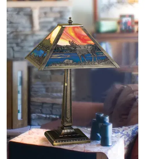 An Moose wanders by a lake in the woods on this nature inspired etched brass lamp shade. The lamp is finished in Mahogany Bronze with Stormy Orange and Blue Green stained art glass panels; and is handcrafted in the USA by Meyda artisans. - alternate view
