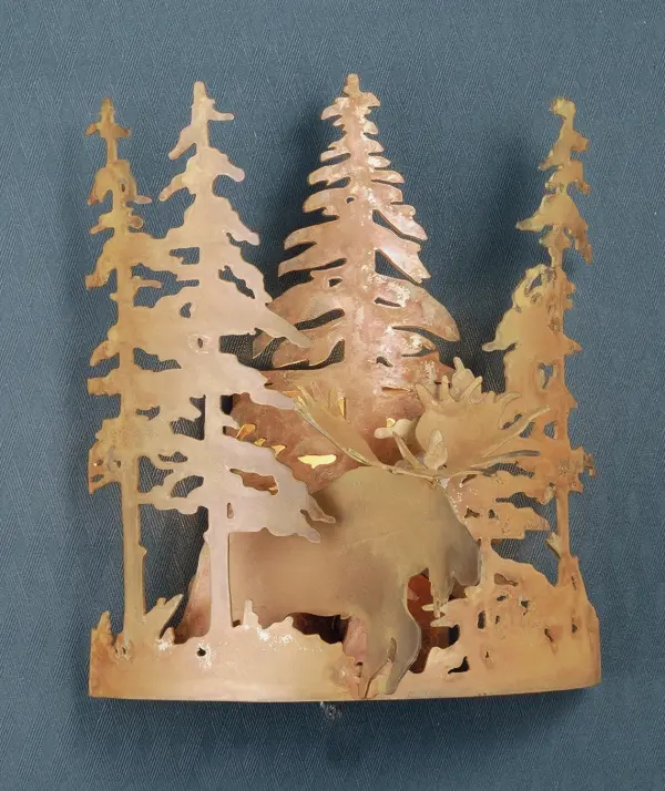 A Moose peers through the tall pines on this wall sconce handcrafted in the USA by Meyda artisans. This nature inspired fixture is finished in Rust. Collection: Moose Through The Trees Finish: Rust Glass: White Width: 11.00" Height: 12.50" Length: 8.00" Weight: 2.50 lb Extension from Wall: 8.00" Number of Bulbs: 1 Maximum Wattage: 60.00 W Bulb Type: B10 Bulb Base: E12 Material: Steel Country of Origin: USA Safety Listing: Dry Safety Rating: Damp