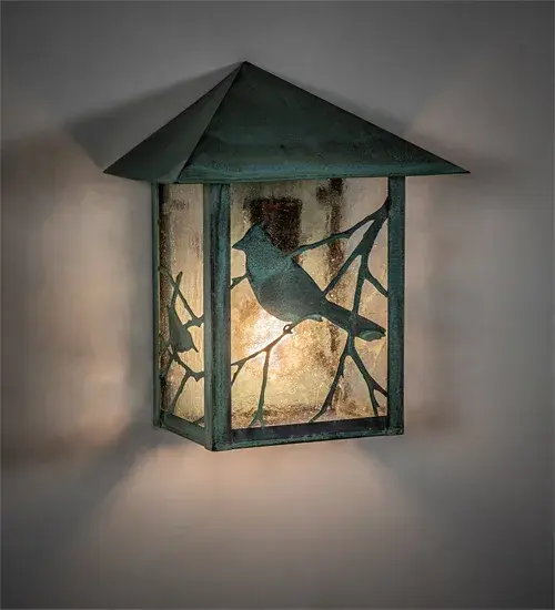 Branches with Song Bird silhouettes accent this handsome American Craftsman lantern style wall sconce. The fixture; handcrafted in the USA by Meyda artisans; is finished in Verdigris and has Clear Seedy glass panels.