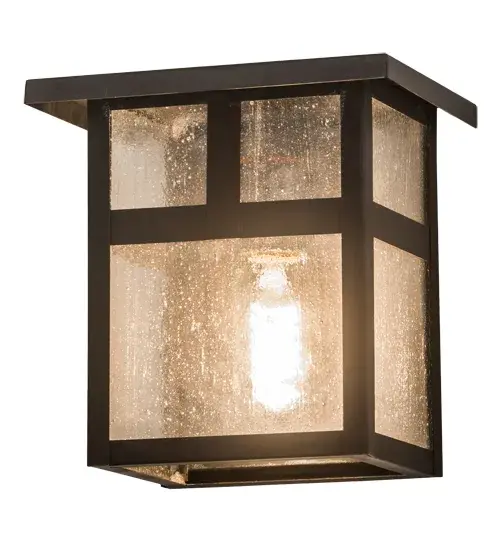 The T Mission has Arts and Crafts style T bars that accents this handsome American Craftsman lantern style wall sconce. The fixture, handcrafted in the USA by Meyda artisans, is finished in Craftsman Brown and has Clear Seeded glass panels. Collection: Hyde Park Finish: Craftsman Brown Glass: Clear Seeded Glass Width: 8.00" Height: 8.00" Length: 6.00" Weight: 3.00 lb Extension from Wall: 6.00" Number of Bulbs: 1 Maximum Wattage: 60.00 W Bulb Type: A19 Bulb Base: E26 Material: Brass Country of Origin: USA Safety Listing: Wet Safety Rating: Wet - alternate view