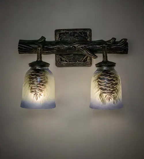 Inspired by nature; hand painted Pinecones and branches of Tan and Bark Brown with Pine Green needles against a Sky Blue ground; grace these distinctive glass shades. Two shades are suspended from a Pine branch detailed two light sconce in a Golden Pine finish.