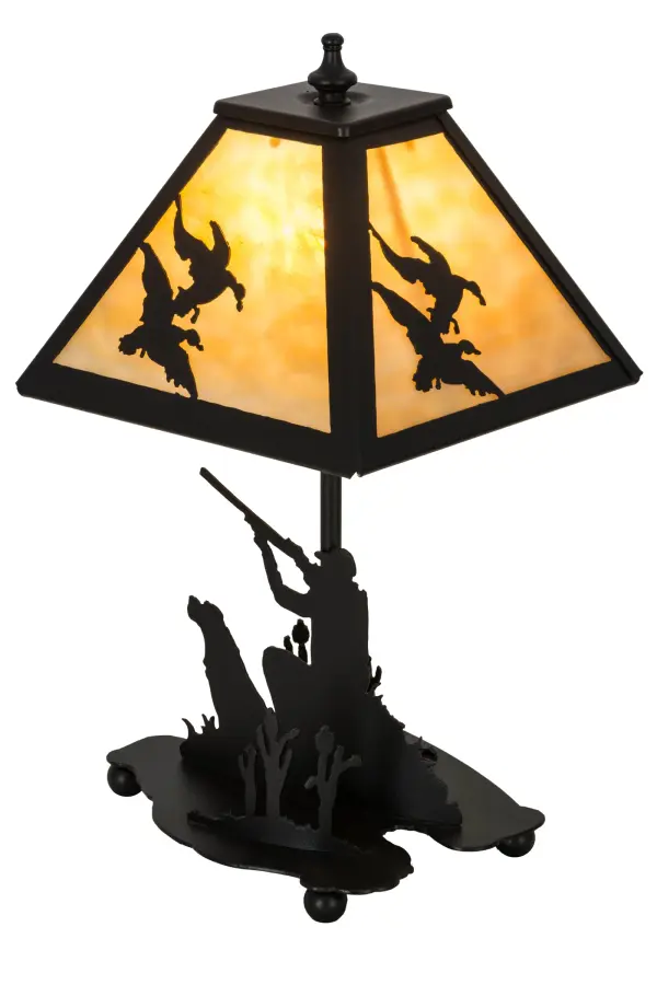 This striking lamp design features silhouettes of a sportsman hunting duck in the woods with a trusty dog by his side. Beautiful ambient light projects through the Beige art glass shade featuring Ducks in flight design and perched on the accent lamp base. The decorative accents, frame and base are featured in a bold Black Textured finish.Handcrafted by skilled artisans in our manufacturing facility at the foothills of the Adirondack Mountains, the lamp is available in custom designs, sizes and styles. Energy efficient lamping options are available.This indoor accent is UL and cUL listed for dry locations. Collection: Duck Hunter Finish: Textured Black Textured Black Glass: Beige Art Glass Width: 11.00" Height: 15.00" Length: 8.00" Weight: 3.50 lb Number of Bulbs: 1 Maximum Wattage: 60.00 W Bulb Type: B10 Bulb Base: E12 Material: Metal Or Polyresin Country of Origin: USA Safety Listing: Damp Safety Rating: Damp