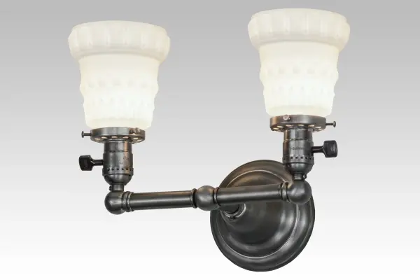 Nostalgia revisited. An era of style and charm is restored with this early reproduction. The Chelsea wall sconce offers Acid Washed White art glass shades with decorative garland-like motifs. The shades are enhanced by traditionally styled hardware which is finished in Antique Nickel. Many other finishes are available. Handcrafted by Meyda artisans in Yorkville; New York.