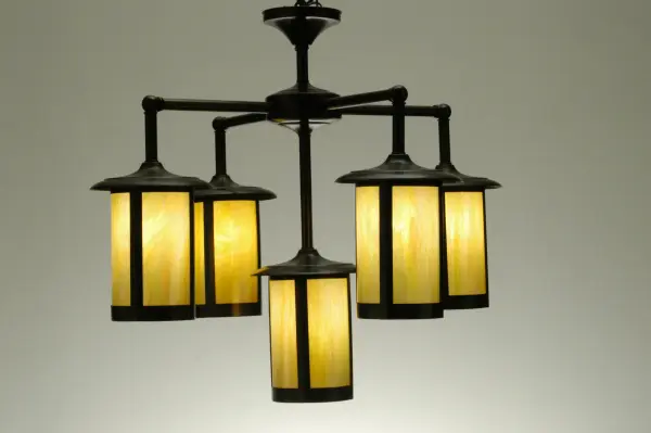 Handcrafted from Solid Brass with alluring rustic beauty. Five stunning Craftsman Signature lanterns feature Beige Iridescent Glass diffusers enhanced with a Craftsman Brown finish. Display this chandelier in entryways and dining areas to illuminate the interiors of timber homes; modern farmhouses; and other spaces. The Fulton Prime 5 Light Chandelier is included in our American-made; American-designed; handcrafted Craftsman Signature Series; manufactured in Yorkville; New York. UL and cUL are listed for dry; damp; and wet locations. Our Build Your Own Craftsman Signature Series features unlimited combinations of styles. The collection is called Build Your Own because it is fully configurable and customizable from size and design to finish and lens color. Marine grade; solid brass; or copper raw materials are utilized to ensure items from the Craftsman Signature Series of outdoor and indoor lighting will stand the test of time; as these premium metals are impervious to most types of oxidation. Hand-applied Patina finishes on brass and copper are sealed with a clear varnish and over time; may require gentle maintenance; such as wax; to delay or reverse the natural living finish attributes indicative of this finishing process. Patina finishes on brass and copper provide strong resistance to fading from sun exposure; will not chip or crack; and will not rust like a steel-framed item in the same conditions. Choose from many style options; or send us your concept today! Call today to learn how to use the configuration tool available on our website for an instant item number!