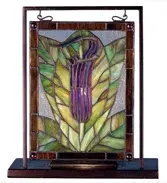 Wandering through the woods you might happen on the elegant Jack-in-the-Pulpit that is represented in Amethyst and Wood Green in this charming mini window. Handcrafted utilizing the copperfoil construction process and stained art glass encased in a solid brass frame; each window hangs perfectly in it's own brass tabletop display.