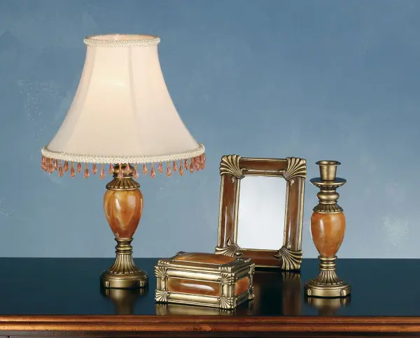 Flute and bead accented Antique Brass hand finished elements surrounds Carnelian stone in this charming four piece vanity set. Goldenrod fabric shades, edged with Amber Blush crystal cut beads are the perfect finishing touch to the smartly designed lamp. The set also includes a jewelry box, candlestick and frame with glass and mirror to be used as a picture or mirror frame. Collection: Boca Raton Finish: Ant Brass/Carnelian Glass: Ant Brass/Carnelian Width: 2.00" Height: 10.00" Weight: 1.50 lb Number of Bulbs: 1 Maximum Wattage: 40.00 W Bulb Base: E26 Material: Steel Country of Origin: CHINA Safety Listing: Dry Safety Rating: Dry