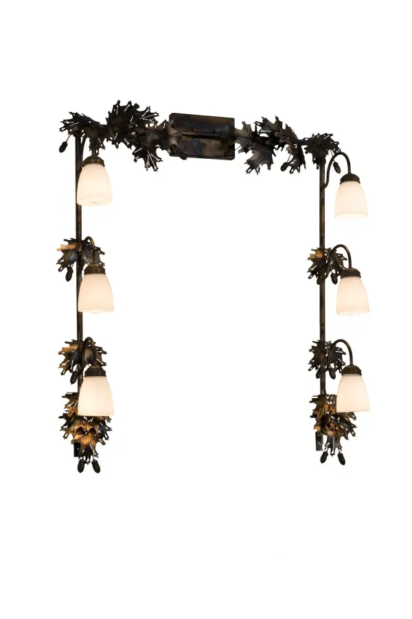 Drawing inspiration from the Mighty Oak; this unique Vanity luminaire is custom designed to outline a mirror in a bath or other rooms. The fixture features delicate steel Oak Leaves and Acorns offered in a Dark Burnished Antique Copper finish.The frame embraces 6 White Art Glass shades to deliver functional down lighting.Custom crafted in the USA; this fixture is available in custom styles; sizes; colors and dimmable energy efficient lamping options such as LED.The fixture is UL and cUL listed for damp and dry locations.