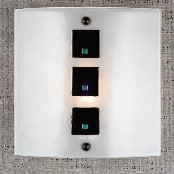 All suited up in our finest array the Black Tie Affair sconce with its square Ebony buttons touched with a drop of dichroic glass set on this Linen White fused glass sconce shade. Metro Fusion is designed and created by Meyda artists and craftsmen of hand cut pieces of glass which are fused together at a high temperature. The glass is mounted on a Nickel powder coated sconce which is ADA compliant. Collection: Metro Fusion Finish: Nickel Glass: Clear/Black Square/Dicro Width: 11.00" Height: 11.00" Length: 3.25" Weight: 3.00 lb Extension from Wall: 3.25" Number of Bulbs: 1 Maximum Wattage: 60.00 W Bulb Type: T10 Bulb Base: E26 Material: Steel Country of Origin: USA Safety Listing: Dry Safety Rating: Dry