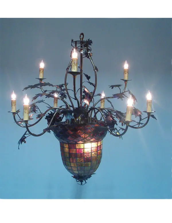 Majestic as the mighty oak is this leaf adorned 9 arm chandelier in an antique copper finish. A lighted stained glass acorn; in multi toned Autumn Green with a Bark Brown granite glass crown that sprouts candle topped; oak leaf covered branches. Each branched arm has with a beautifully simulated dripping wax candlestick in Ivory. The elegant hardware is hand made in the U S A by Meyda Tiffany Craftsmen.