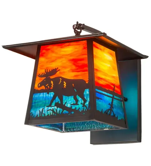 A majestic Moose meanders alongside a woodland lake as the brilliant morning sun rises at dawn. The design makes an image that is perfect for picture postcards and great works of art. Eye-catching Sunburst art glass depicts the sky as Blue-Green Ripple Glass represents the water. This sconce features decorative accents and hardware in a Craftsman Brown finish. Made to Order in our 180;000 square foot manufacturing facility in Yorkville; New York; located at the foothills of the Adirondack Mountains. Additional wildlife and custom designs available; as well as custom shade colors; finishes and sconce sizes. UL and cUL listed for dry; damp and wet locations. - alternate view