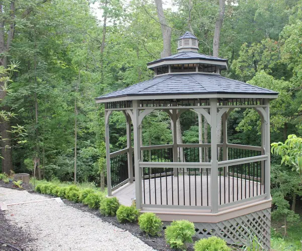 Embrace the warmth of natural aesthetics with Berlin Gardens' Wood Octagon Gazebo, where classic design meets enduring craftsmanship. This thoughtfully crafted structure adds a touch of rustic charm to your outdoor space, creating an inviting haven for gatherings and moments of serenity beneath the open sky. Standard Model Includes: • Regular roof • American style rail • Metal or asphalt shingles • Cupola - alternate view