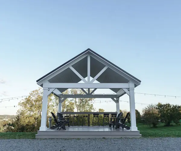 Experience the epitome of outdoor grandeur with our Wellington Pavilion. Meticulously crafted for enduring beauty and structural excellence, this pavilion redefines alfresco living, offering a stunning focal point for your gatherings and creating an ambiance of timeless sophistication in your outdoor space. Standard Model Includes: • Pressure treated wood wrapped with cellular PVC • Paintable • 8×8 posts • 8/12 pitch roof • Painted rafters with exposed pine sheathing • 12" overhang