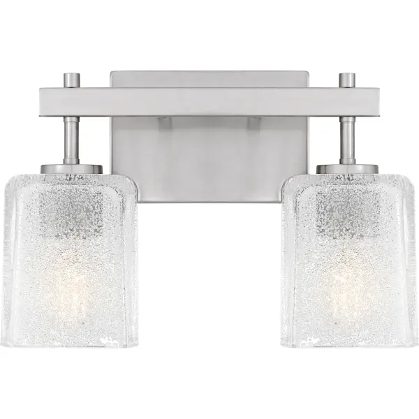 The Brenthouse bath light features a clean, minimalist design with a striking visual impact. Square glass shades cast a soft, diffused glow while adding a touch of texture to the simple silhouette. The thick glass shades feature tiny crystals on the inside, creating a look reminiscent of sparkling sand. The vanity light's slender metal frame, available in a versatile matte black or brushed nickel finish, complements a variety of bathroom styles.
