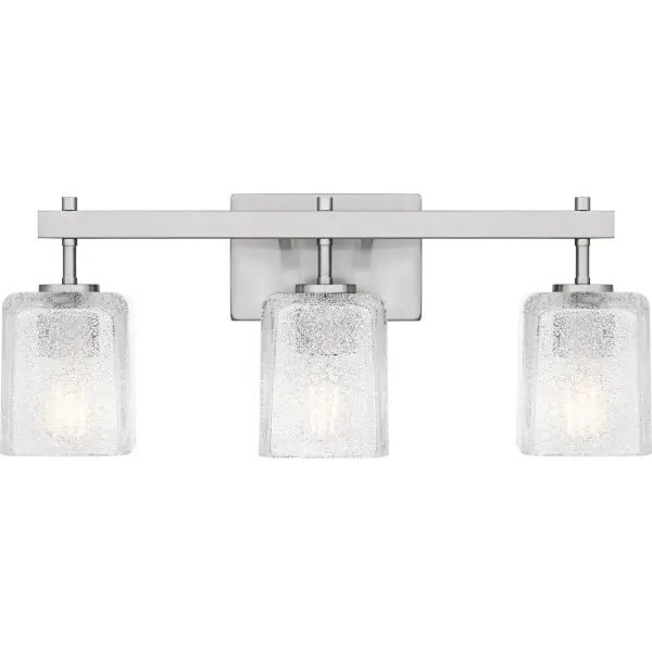 The Brenthouse bath light features a clean, minimalist design with a striking visual impact. Square glass shades cast a soft, diffused glow while adding a touch of texture to the simple silhouette. The thick glass shades feature tiny crystals on the inside, creating a look reminiscent of sparkling sand. The vanity light's slender metal frame, available in a versatile matte black or brushed nickel finish, complements a variety of bathroom styles.