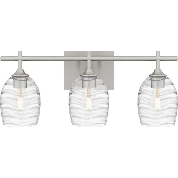 Clear optic glass shades feature a rippling, wavelike pattern that evokes serene movement in the Lucy bath light. Clean lines and your choice of matte black or brushed nickel finish complete the look, making Lucy a perfect complement to transitional or coastal inspired bathroom vanity settings. Install with shades facing up or down - whichever best suits your preference. Collection: Lucy Rooms: Bathroom Finish: Brushed Nickel Glass: Clear Optic Glass Width: 22.00" Height: 9.25" Length: 6.50" Weight: 6.07 lb Extension from Wall: 6.50" Wire: 6" Canopy: 6.500"x5.000" Number of Bulbs: 3 Maximum Wattage: 100.00 W Bulb Type: E26 Bulb Base: Medium Voltage: 120.00 V Material: Steel Safety Listing: ETL Spec Sheet Instructions