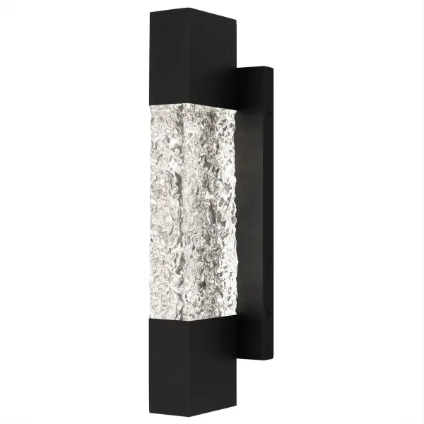 Add a touch of contemporary luxury to your home's exterior with Solace wall lanterns. The sleek silhouette is complemented by a solid piece of handmade clear textured glass, allowing the integrated LED light source to shine through brightly. The elongated matte black frame is made to withstand the elements, making it a great choice year round. Flank your front door with a pair of Solace wall lights or use as a porch light to create the perfect backyard setting. Due to the handmade nature of the glass, slight variations add unique character to each fixture.
