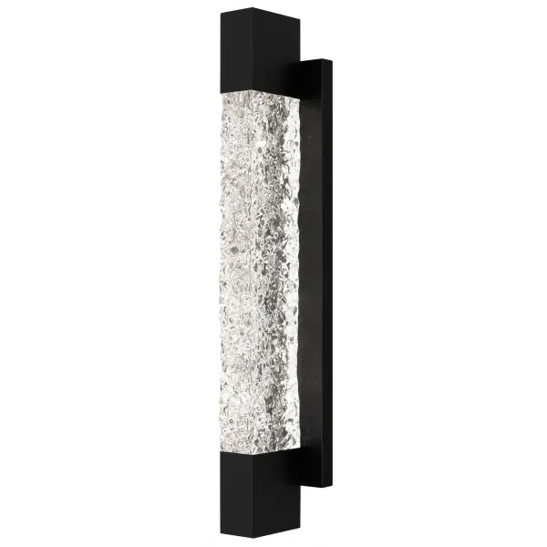 Add a touch of contemporary luxury to your home's exterior with Solace wall lanterns. The sleek silhouette is complemented by a solid piece of handmade clear textured glass, allowing the integrated LED light source to shine through brightly. The elongated matte black frame is made to withstand the elements, making it a great choice year round. Flank your front door with a pair of Solace wall lights or use as a porch light to create the perfect backyard setting. Due to the handmade nature of the glass, slight variations add unique character to each fixture.