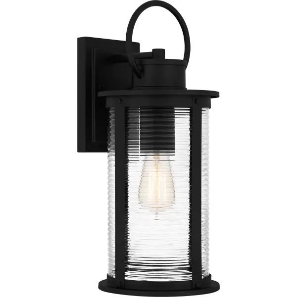 Tilmore outdoor lanterns are the perfect companion to coastal-inspired exteriors. The sturdy matte black frame is accentuated by clear ribbed glass for a classic look, designed to withstand the elements in style. Available as a hanging lantern, post lantern, and various sizes of wall lantern, Tilmore is an easy way to illuminate a front porch or landscape.