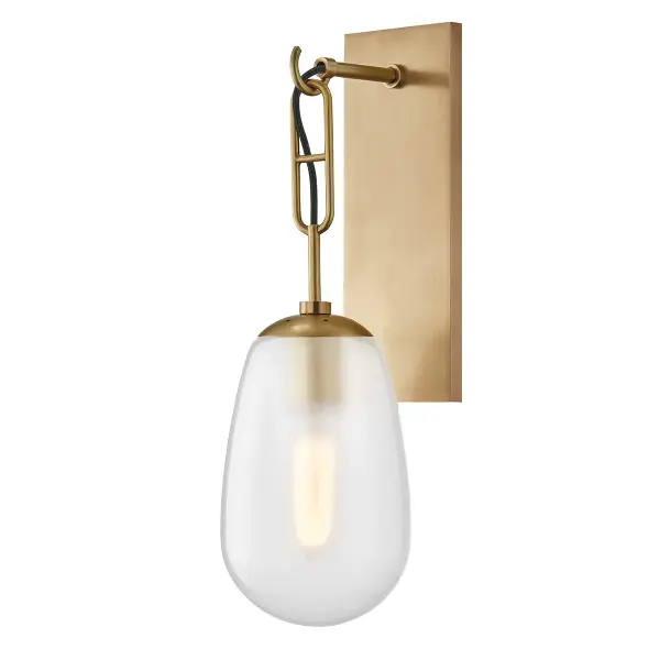 The Bruckner wall sconce combines classic proportions with contemporary refinement. Its aged brass finish and clear etched glass shade deliver warm, diffused light perfect for intimate spaces.
