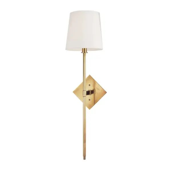 The Cortland wall sconce combines geometric precision with soft fabric warmth. Its distinctive diamond-shaped arm and aged brass finish create a sophisticated focal point perfect for transitional and contemporary interiors.