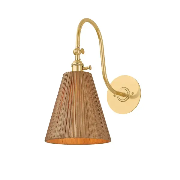 The Ruthin wall sconce blends natural rattan with aged brass metalwork in a gestural gooseneck design. Its swivel head provides precise directional lighting, making it ideal for reading nooks and task areas while adding organic warmth.