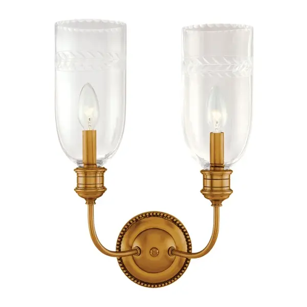 The Lafayette wall sconce brings sophisticated traditional styling with its aged brass finish and clear glass shades. Perfect for flanking mirrors or creating ambient lighting in transitional spaces.