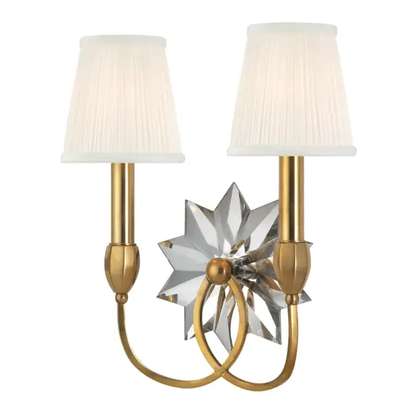 A sophisticated wall sconce that honors American colonial design with its 20-facet crystal star backplate and warm aged brass finish. The pleated silk shade softens the light while the mirrored crystal amplifies ambiance.